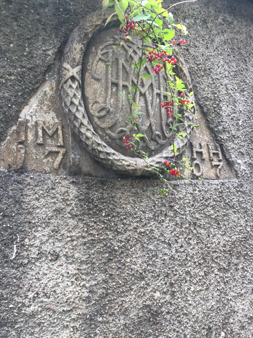 Close-up of the carved stone crest with trailing red berries